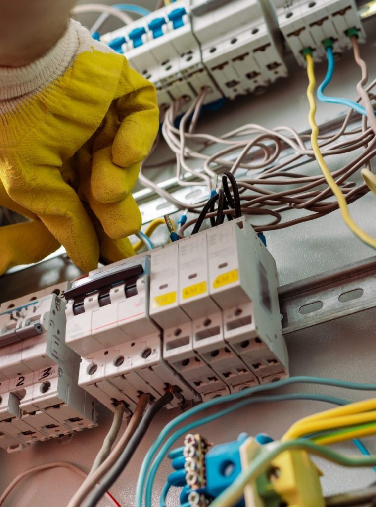 low-angle-view-of-electrician-in-gloves-fixing-electrical-distribution-box-e1624860007883-p9bghdhkylh4glyn53sabhlkflzef1vyokfz0i98n4